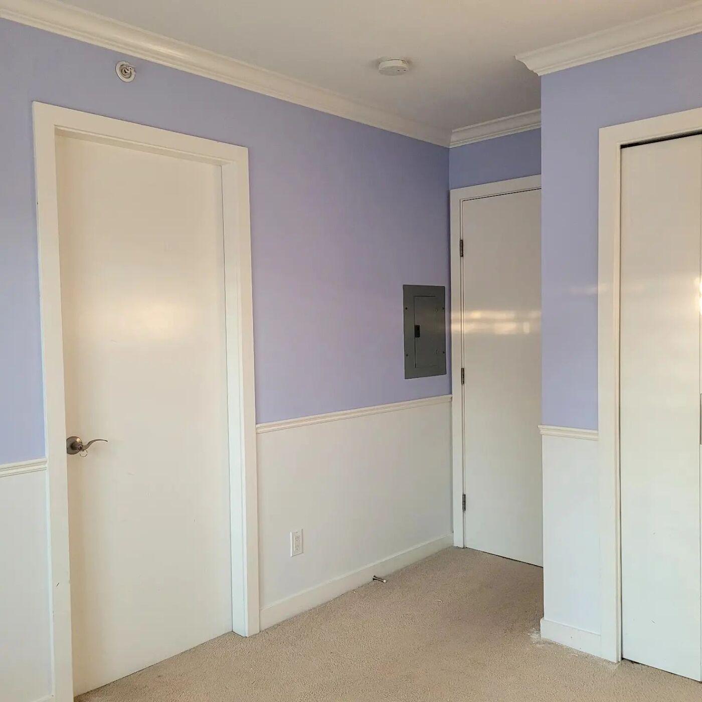A residential interior with a soft lavender accent wall meeting crisp white wainscoting — recent Davor's Painting Co. project.